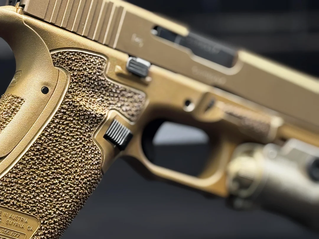 Macro detail of hand-cut stippling on a bronze Cerakote frame